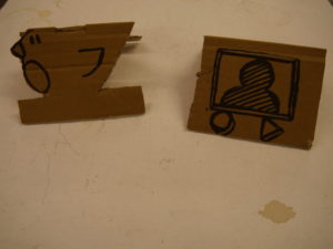 cardboard models of a bird and a screen with a person on it