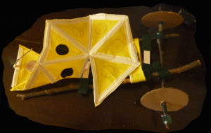 a model of wheeled device with a fold out sheet with dots on it and a microphone made from card, twigs and tape