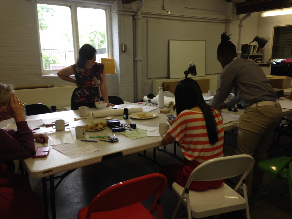 Rachel standing at a table in Furthefield with 3 participants working