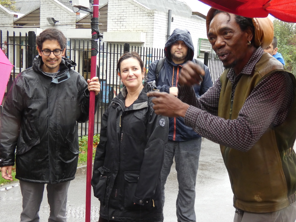 Alex Dayp talking with Rachel Jacobs, Sebastian Gaete holding the weather station pole and Dominic Price - in the rain in Finsbury Park