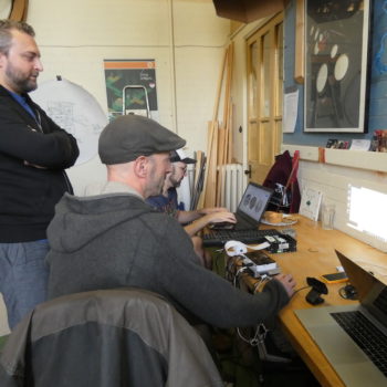 Robin Shackford and Dominic Price working at laptops, with the printer and projector
