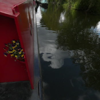 the side of our red narrowboat and the river below