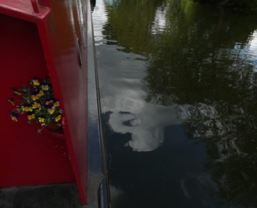 the side of our red narrowboat and the river below