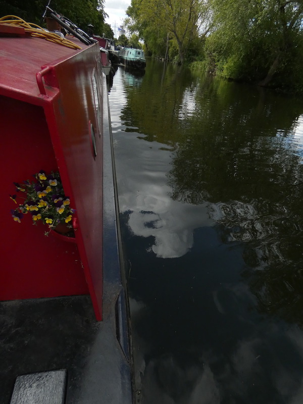 the side of our red narrowboat and the river below