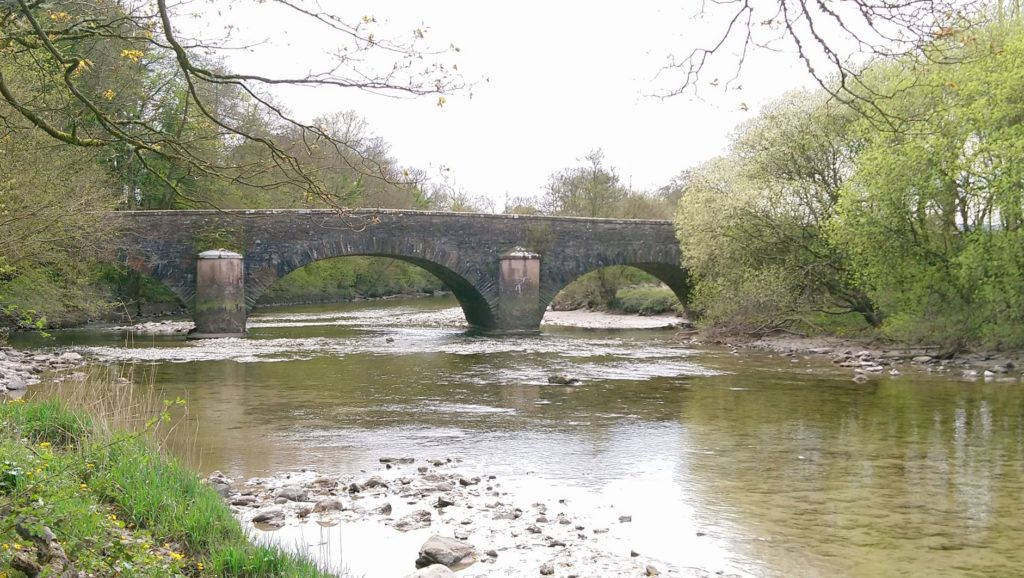 Down river on the Leven, the stone bridge and trees on the banks, the water, stones and slate