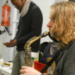 Dave playing the saxophone with Miles behind playing a Mbira