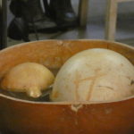 A water drum close up, a large gourd with water and two gourds inside it