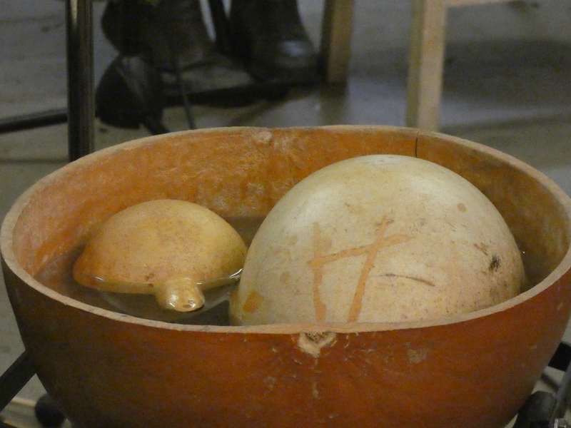 A water drum close up, a large gourd with water and two gourds inside it