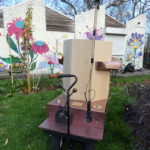 back of the Future Machine in the drumming school garden with the mural behind and the lever and weather pole