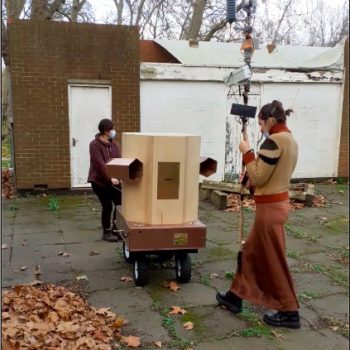 Rachel pulling the Fuutre Machine outside Furtherfield Commons with Indira in front holding the weather station on a pole