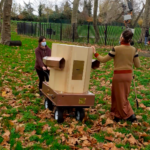 Rachel and Indira pushing the Future Machine up the hill in Finsbury Park amongst Autumn leaves