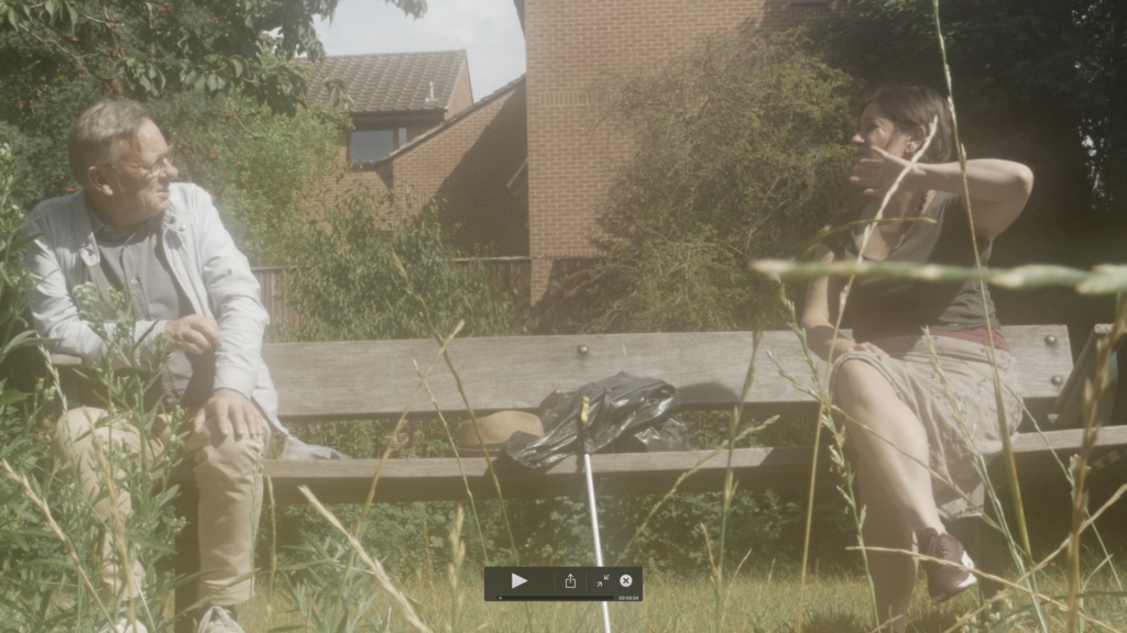 Rachel and Frank sitting 2 metres apart on the bench in Christ Church Gardens with litter picking stuff in Summer 2020
