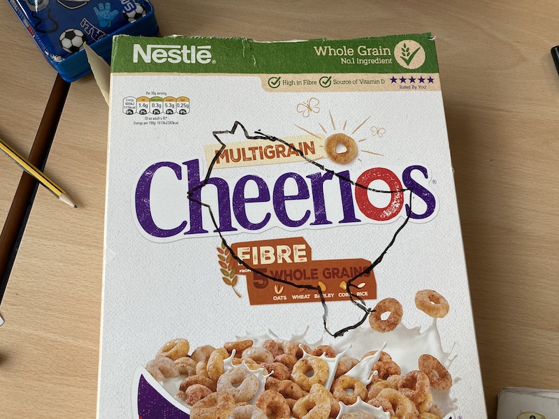 A Cheerios packet with a bird outline drawn on the top