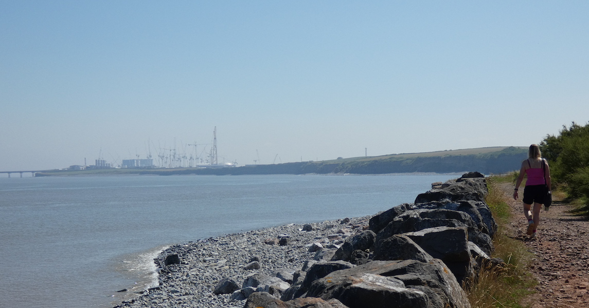 Caroline walking along the coastal path at Kilve with the sea on the left and Hickley Point C nuclear power station in the distance