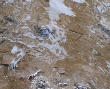 footprints under water, reflections on the water, rocks, mud at the river leven