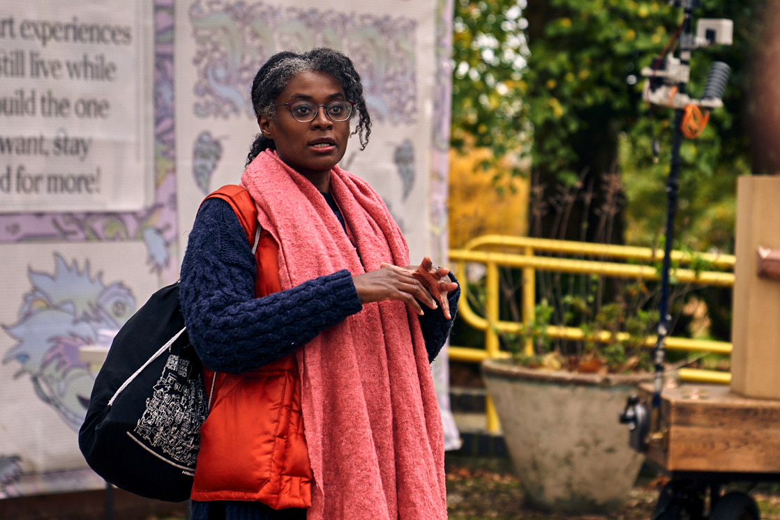 Esi Eshun introducing the procession with Furtherfield Gallery, Autumn trees and the Future Machine in the background