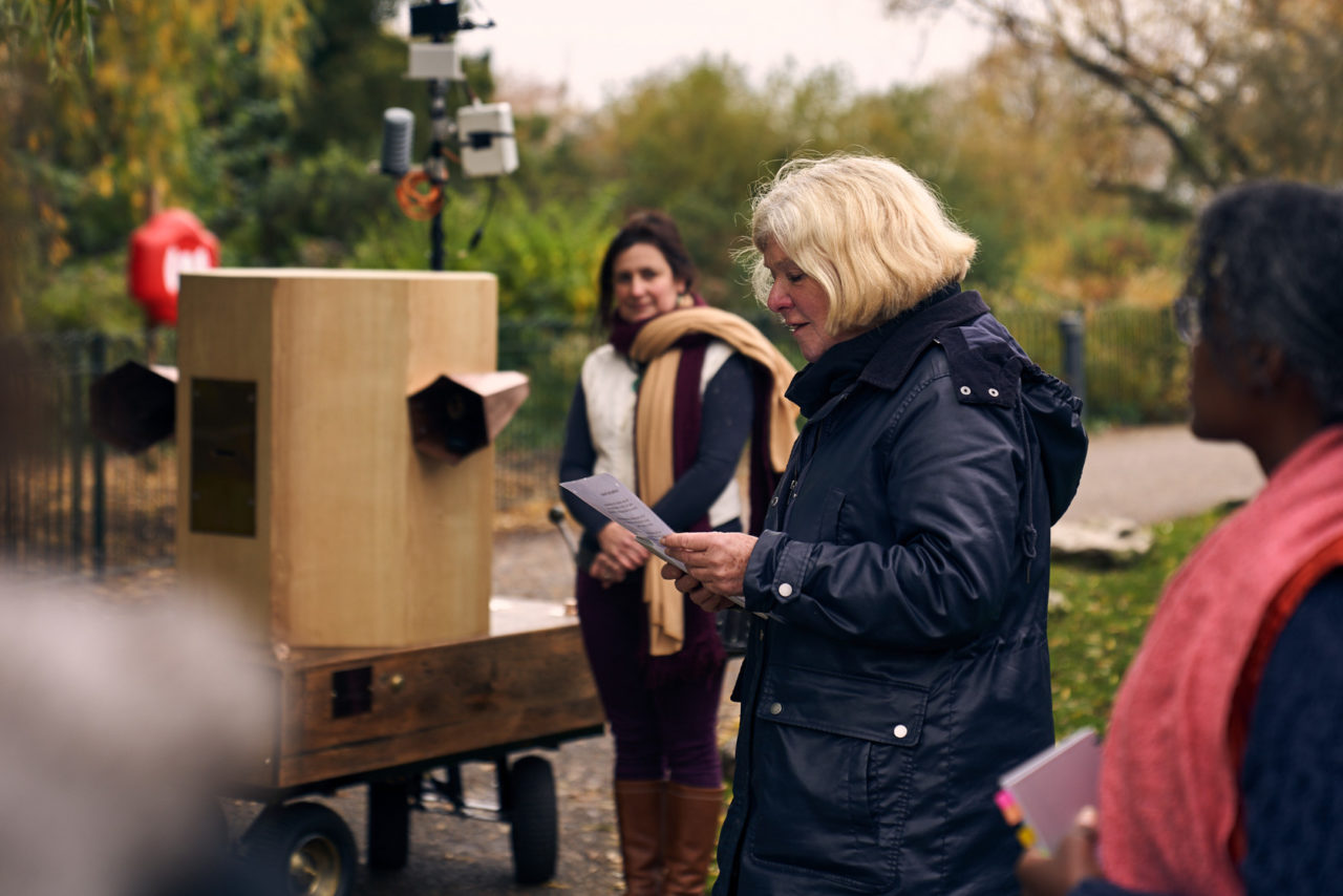 Jo Roach reading a peom with Esi Eshun listening and Future Machine and Rachel Jacobs in the background