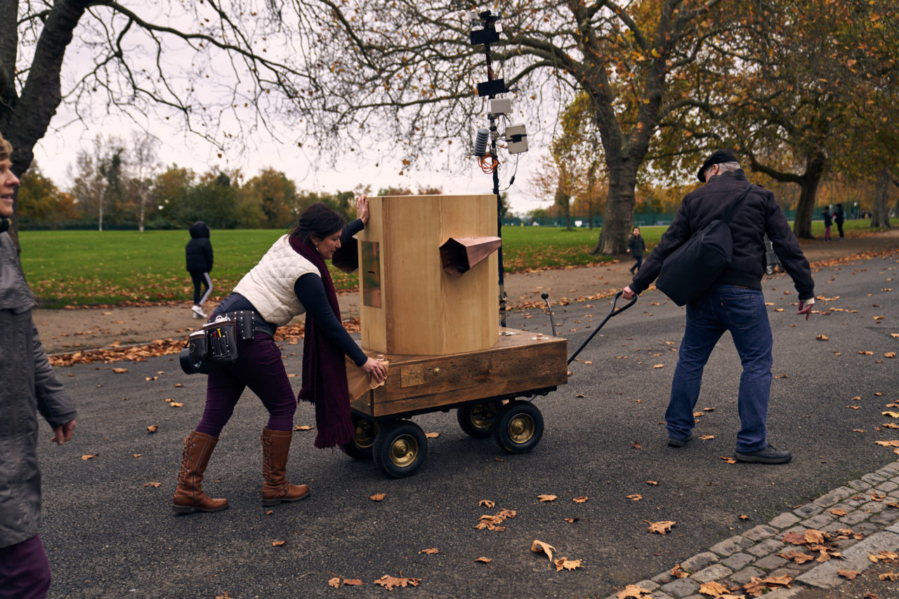 a man pulling the Future Machine up hill with Rachel pushing