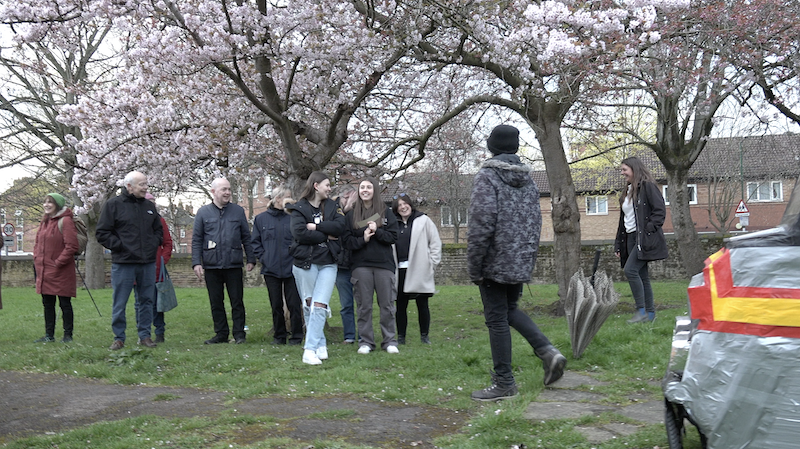 Mr X and some people standing under the blossom trees