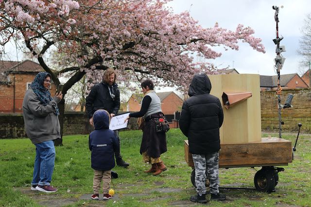 A family, Future Machine and the artist companion under the blossom trees