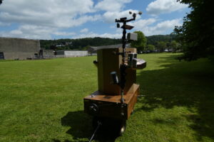 the back of Future Machine and the weather pole in the field with The Lakes School behind