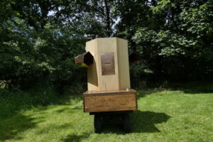 Future Machine in the meadow with the woods behind