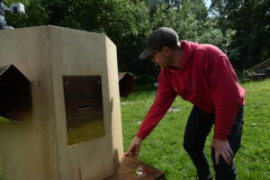 Man in a cap and national trust hoodie pressing the button on the side of Future Machine