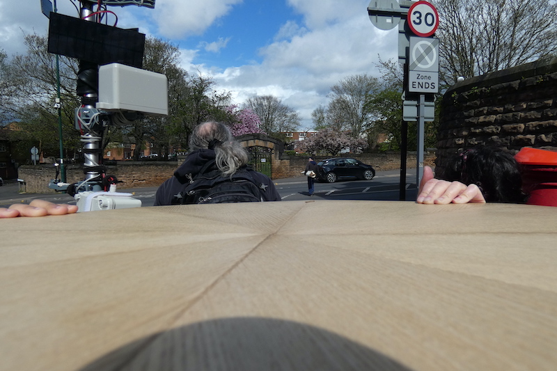 the wooden top of Future Machine, the weather station and people's heads around it with christ church gardens and the blossom trees in the distance