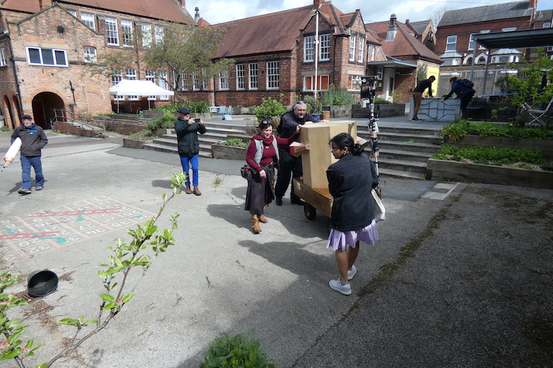 people pushing and pulling Future Machine in Primary's playground with Frank filming