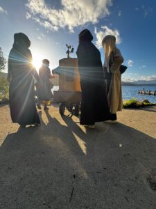 Future Machine with Lake Windermere behind, a low sun, Future Machine's companion and 3 people with around them